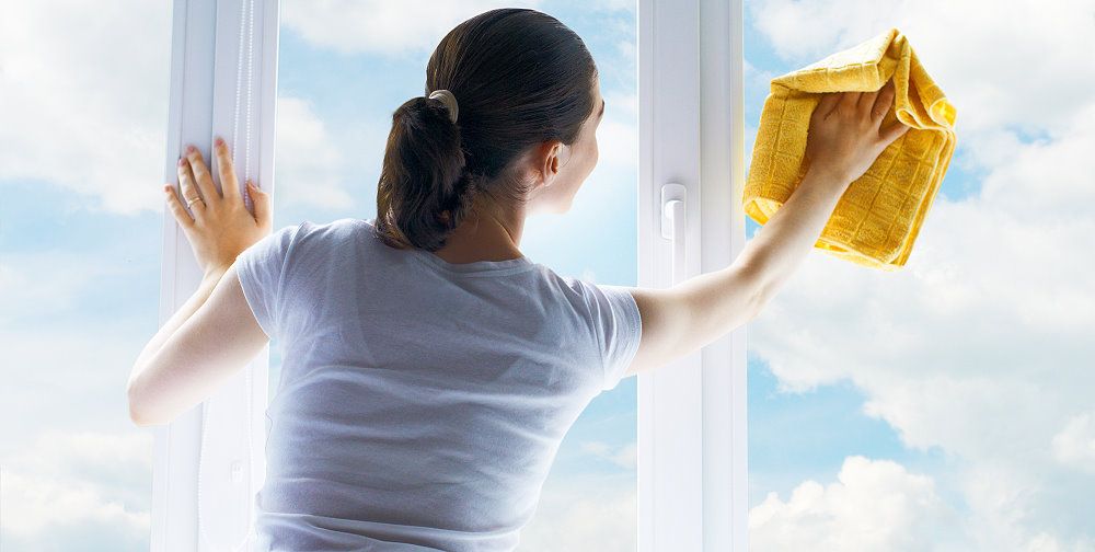 Frau will streifenfrei Fenster putzen