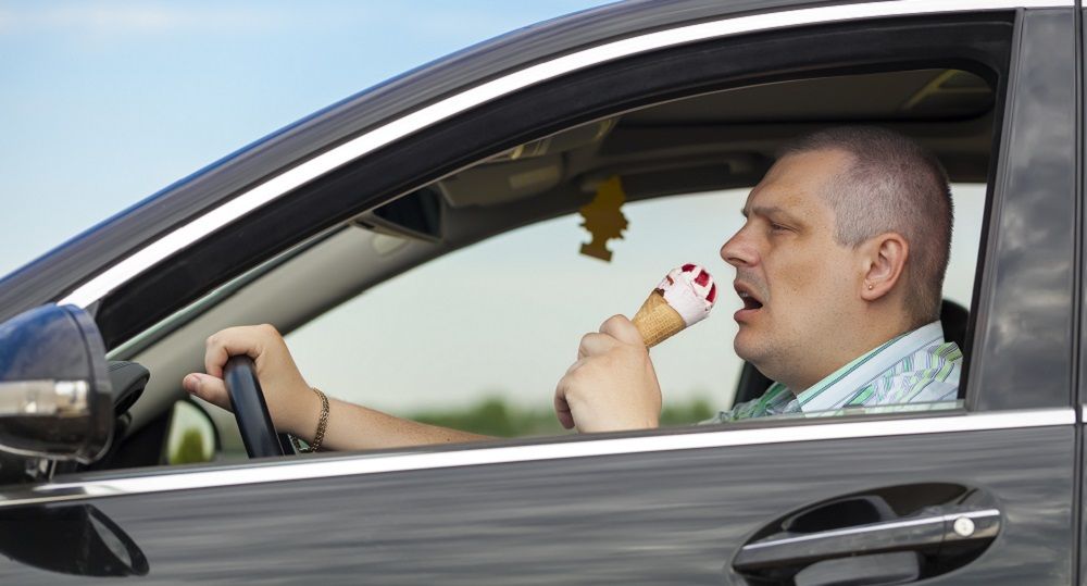 Mann isst ein Eis im Auto
