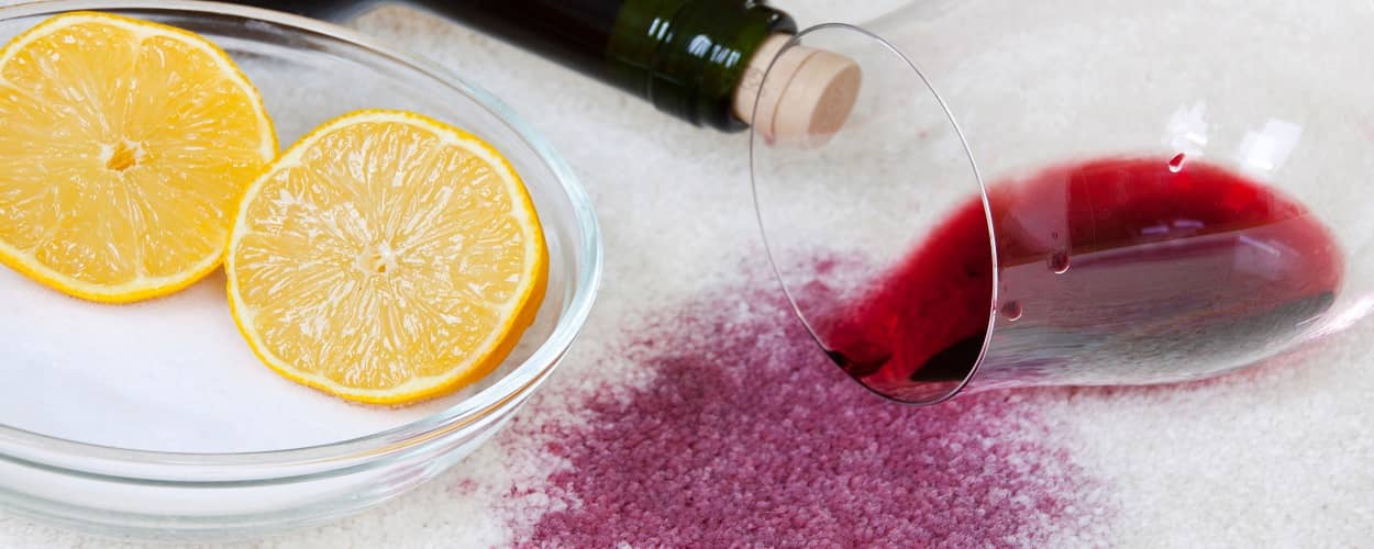 Mit Hausmitteln wie Salz und Zitrone kann man Rotweinflecken aus dem Teppich entfernen.