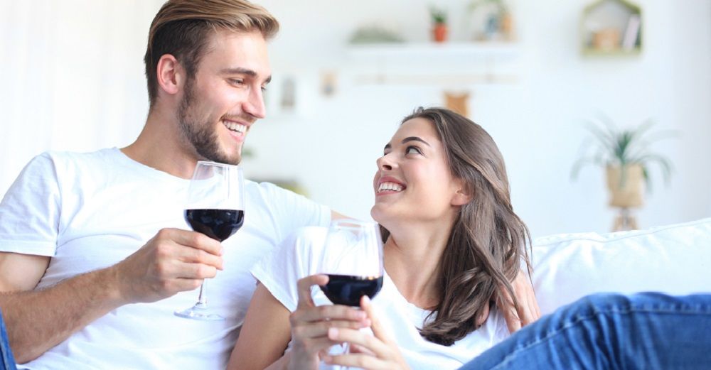 Paar mit einem Glas Rotwein auf einer Couch