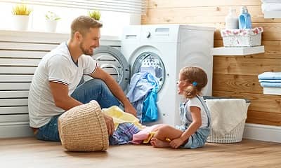 Vater und Tochter beim Wäsche waschen
